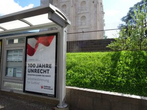 Plakat des „Südtiroler Heimatbundes“ (SHB) in Bozen, im Hintergrund das faschistische „Siegesdenkmal“