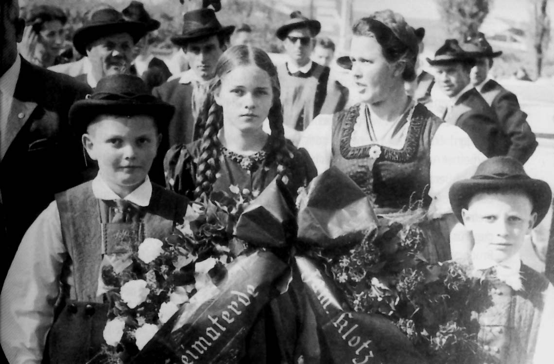 Rosa Pöll-Klotz zusammen mit ihren Kindern auf dem Begräbnis von Luis Amplatz. Das Mädchen mit den langen Zöpfen auf dem Bild ist ihre Tochter Eva.